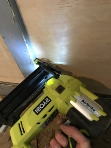 an air nailer shoots brads into garage trim