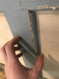 handyman holding a piece of garage door trim in place