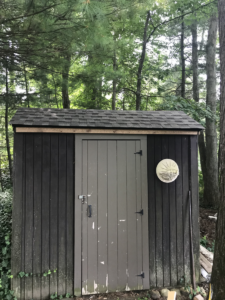 outdated shed with dark siding preparing for new siding