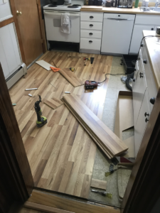 oak laminate flooring being installed in a kitchen in an andover home